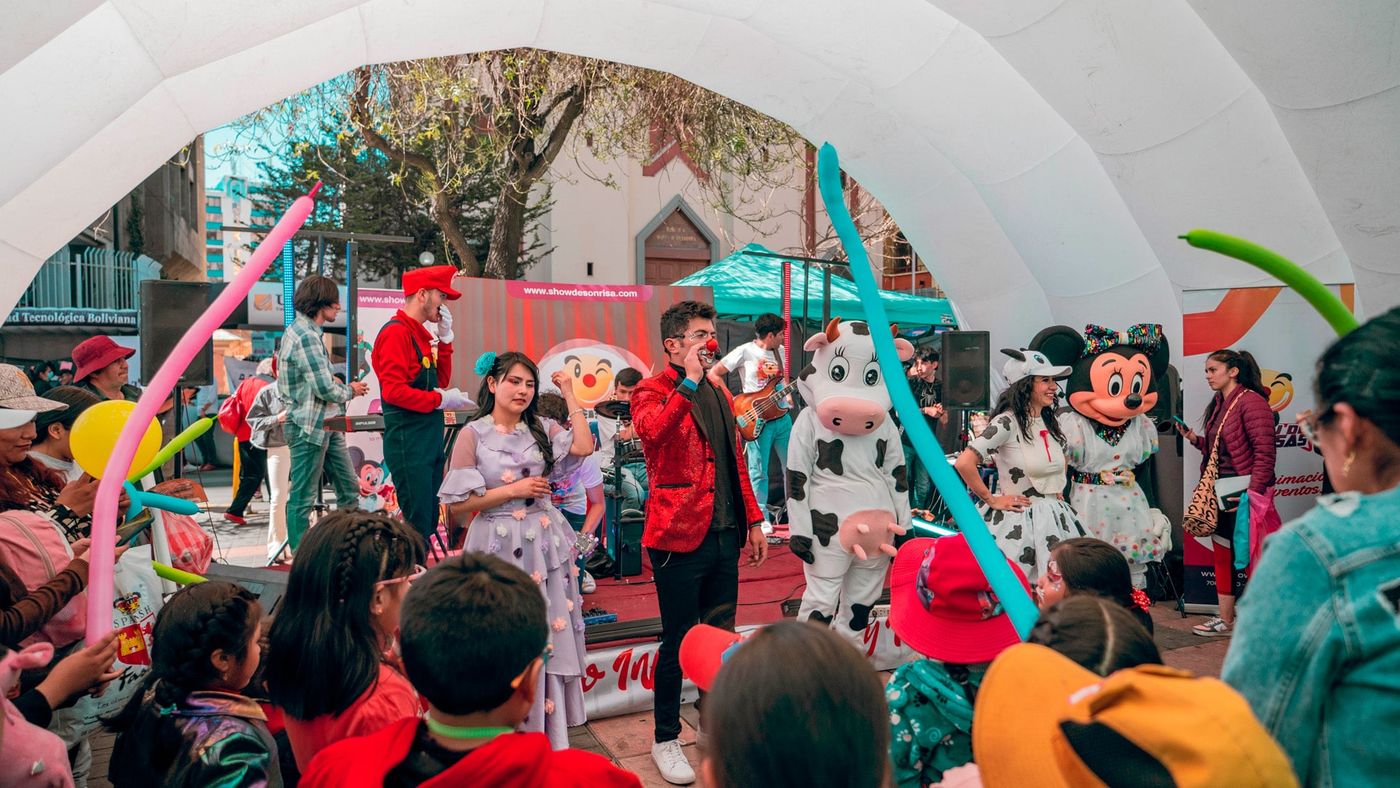 Show de Sonrisas en una plaza de La Paz: animadores, personajes y niños frente al escenario
